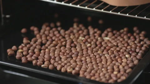 Cook roasts hazelnuts in the oven Stock Footage 53321608