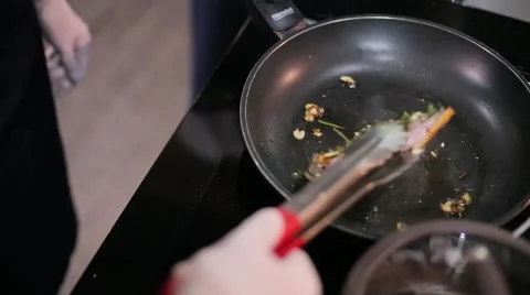 Cook roasts meat in a frying pan Stock Footage 67863188