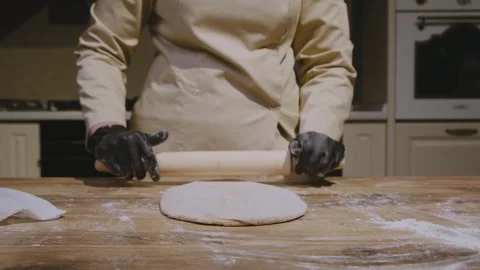 Cook rolling the test with a rolling pin on a wooden table Stock Footage 305306771