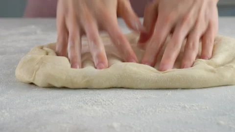 Cook rolls the dough with a rolling pin, shaping the dough. Female hands Stock Footage 141368724