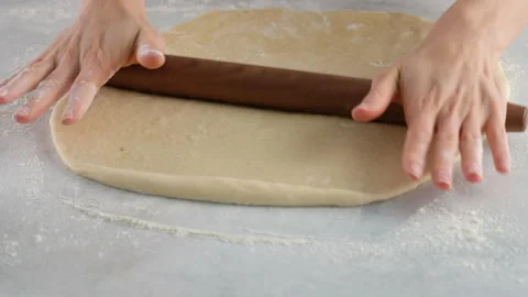 Cook rolls the dough with a rolling pin, shaping the dough. Female hands Stock Footage 141368774