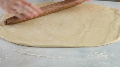 Cook rolls the dough with a rolling pin, shaping the dough. Female hands Stock Footage 145482684