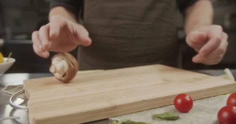 Cook rolls one big beautiful mushroom on wooden board. 4K Slow Motion Stock Footage 123099588