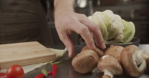 Cook rolls one big beautiful mushroom on wooden board. 4K Slow Motion Stock Footage 123207809