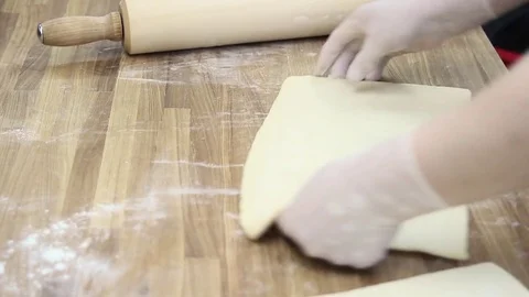 The cook rolls out the dough with a rolling pin Stock-Footage 69993380