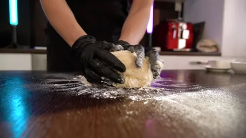 The cook rolls out the dough on the table in slow motion. Stock Footage 171727721
