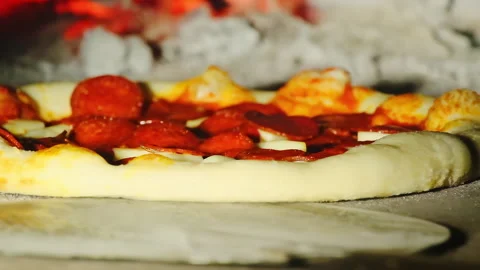 Cook rotates pizza using long-handled metal spatula Stock Footage 326369789