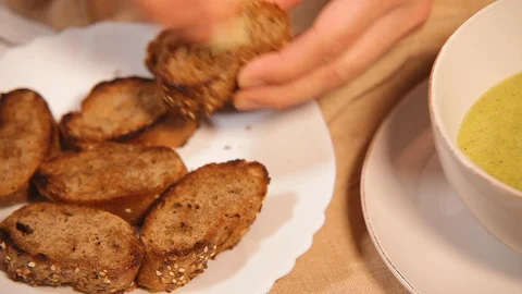 Cook rubs dried up pieces of bread with piece of garlic before serving with soup Video stock 120670547