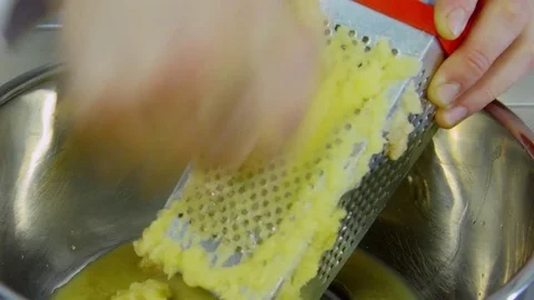 Cook rubs the potato on a grater Stock Footage 70972166