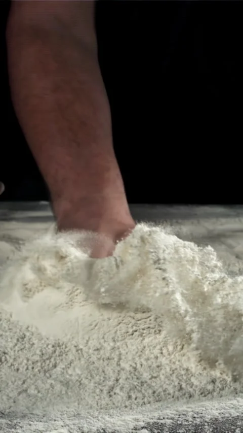 The cook runs his hand over the table with flour. Filmed on a high-speed camera Stock Footage 335357909