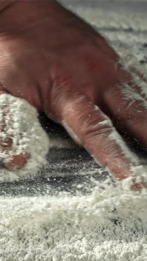 The cook runs his hand over the table with flour. Filmed on a high-speed camera Stock Footage 335361264