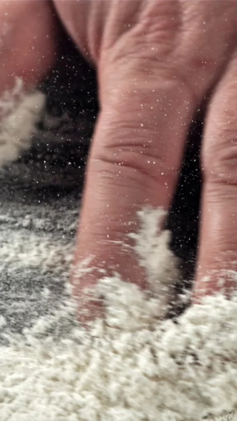 The cook runs his hand over the table with flour. Filmed on a high-speed camera Stock Footage 335361725