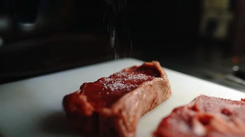 The cook salts an appetizing piece of meat. Stock Footage 145855369