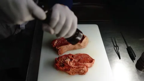 The cook salts an appetizing piece of meat. Stock Footage 145855396