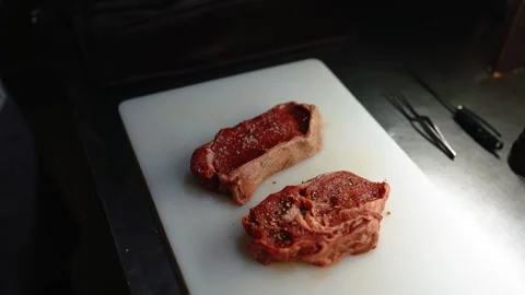 The cook salts an appetizing piece of meat. Stock Footage 145855441