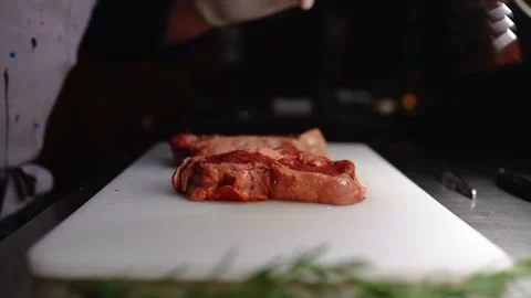 The cook salts an appetizing piece of meat. Stock Footage 145855501