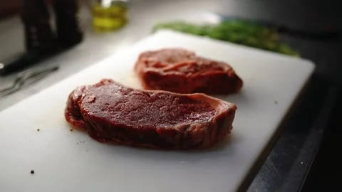 The cook salts an appetizing piece of meat. Stock Footage 145855511