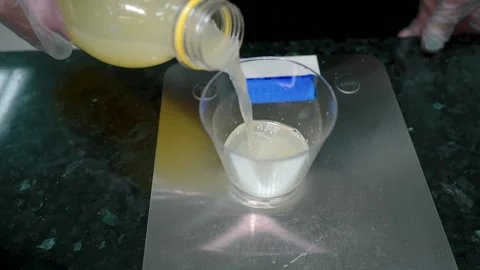 Cook on scale measures portion of yellow liquid and adds it to flour dough. Stock Footage 87322200