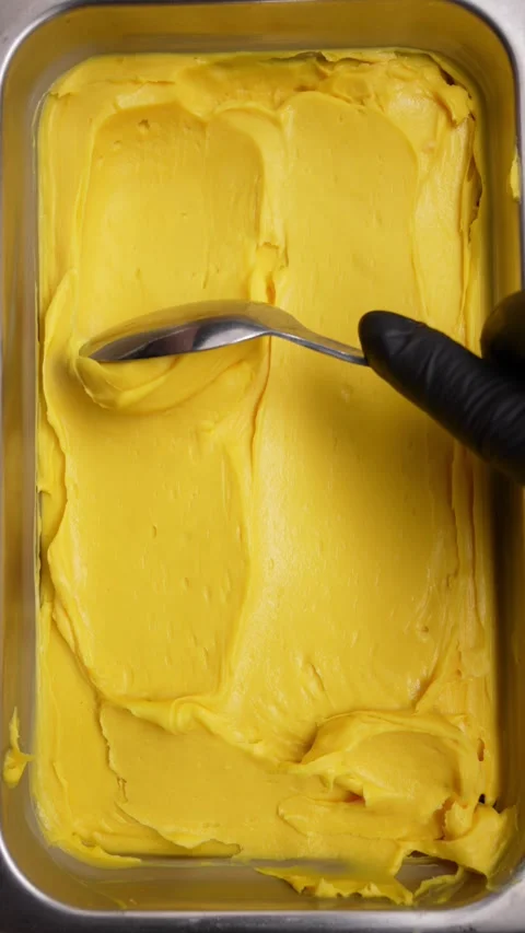 The cook scoops up the cream with a spoon Stock Footage 256089640