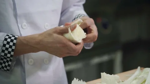 Cook separates leaves from Chinese cabbage in industrial kitchen Stock Footage 71521755