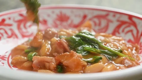 The cook serves bean stew with spinach on the plate. Stock Footage 240376514