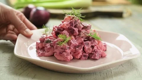 The cook serves beet and potato salad on the table. Stock Footage 234892050