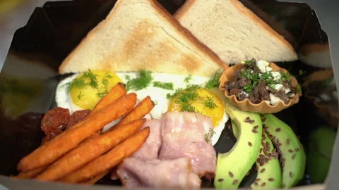 The cook serves breakfast. Fried eggs, avocado, basket, bread, bacon, french Stock Footage 178488569