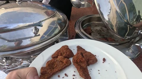 Cook serves fried schnitzel at resort hotel buffet. Man preparing breaded meat Vidéo 331079002