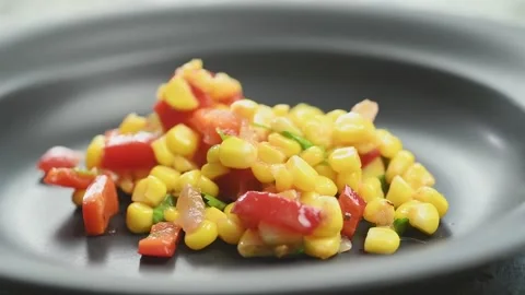 The cook serving corn salad to a plate. Video stock 169048492