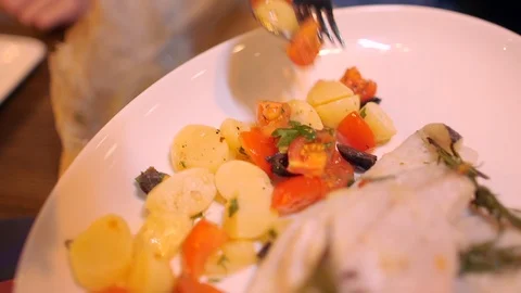 Cook serving fillets of gilt-head bream with side dish on the table Video stock 124856185