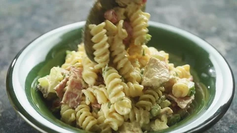 The cook serving the salad with a spoon into the plate. Stock Footage 198533783