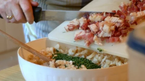 A cook, she puts the eggs and speck into small cubes in the dough of the Video stock 112651136
