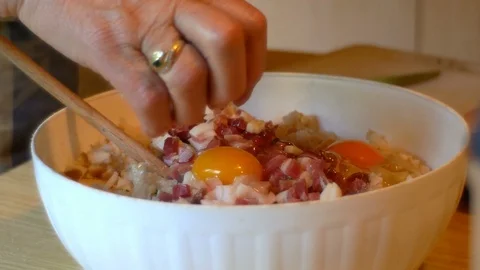A cook, she puts the eggs and speck into small cubes in the dough of the Video stock 112651825