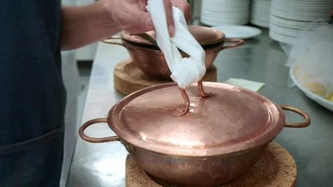 A cook showing clams in copper pot covered with lid Stock Footage 95288950