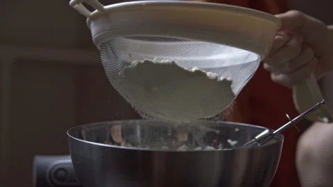 Cook sifting flour into a baking bowl Stock Footage 263185681