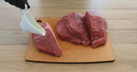 Cook sliced beef steaks with knife watering butter and sprinkling spices 動画素材 123563402