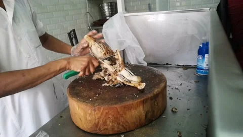 The cook sliced ​​the goat's head with a sharp knife. Stock Footage 130297389