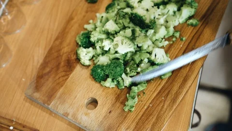 Cook slices broccoli on a cutting Board. The view from the top Stock Footage 123254687