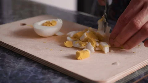 The cook slices eggs for Olivier salad. Stock Footage
