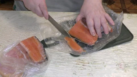 The cook slices the fish for trout Stock Footage 148950458
