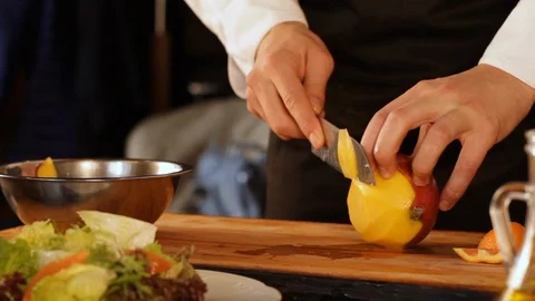 Cook slices mango into thin slices Stock Footage 116680646