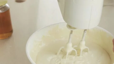 Cook slowly removes the electric mixer from the dough Stock Footage