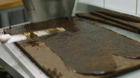 Cook smears jam over the large biscuit cake in the production Stock Footage 77739567