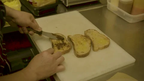 Cook Spreading Condiment on Toasted Bread in Sydney Cafe Kitchen, Australia Stock Footage 345654120