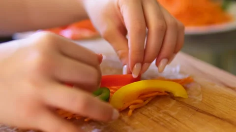 Cook spring rolls with carrots red fish pepper and cucumber vegetables seafood Stock Footage 302082500