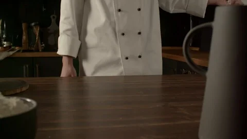 Cook sprinkles flour on a table in the kitchen, cooking pasta in slow motion Video stock 120572805