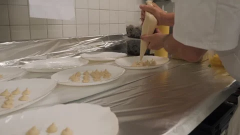 The cook squeezes the cream onto the plates Stock Footage 265681357