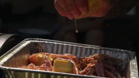 Cook squeezes lemon juice on cooked red river crayfish Stock Footage 250157880