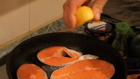Cook squeezes of lemon juice on the fish Stock Footage 99799481