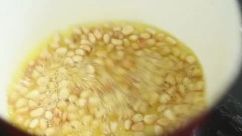 The cook stirring the pine nuts in the frying pan. Stock Footage 200810556